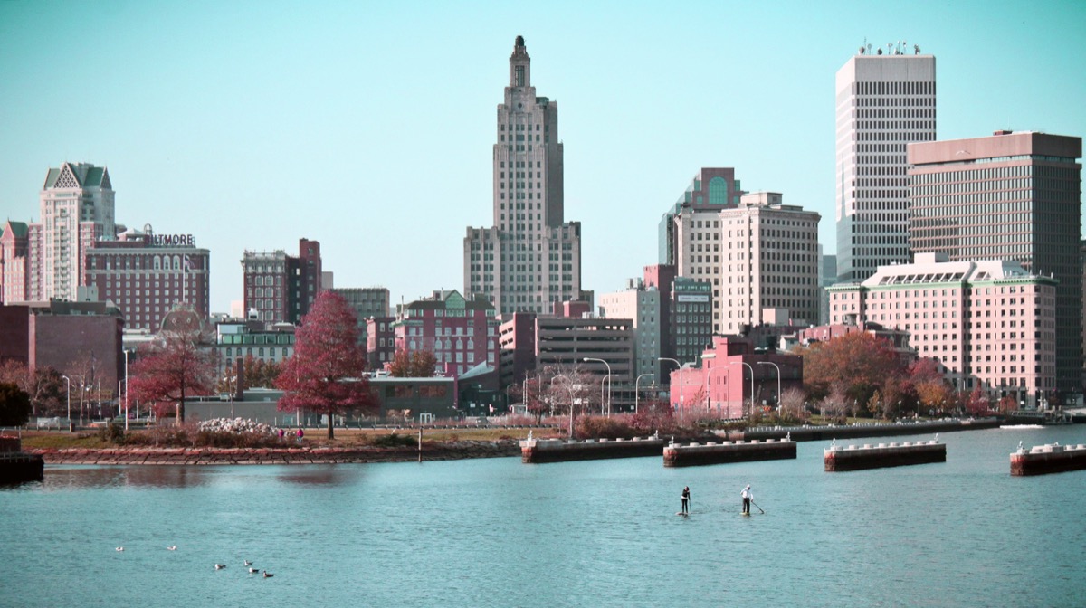 Two paddleboarders on Providence Harbor beneath the city skyline